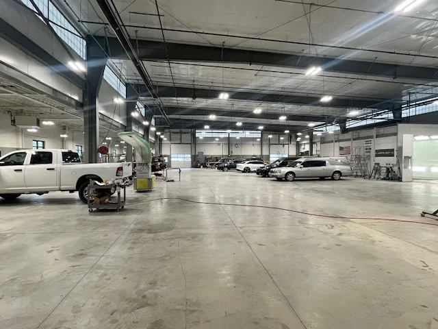 Wide view of the Heritage Collision Experts repair facility showing the scale of the floor, multiple bays, and frame equipment