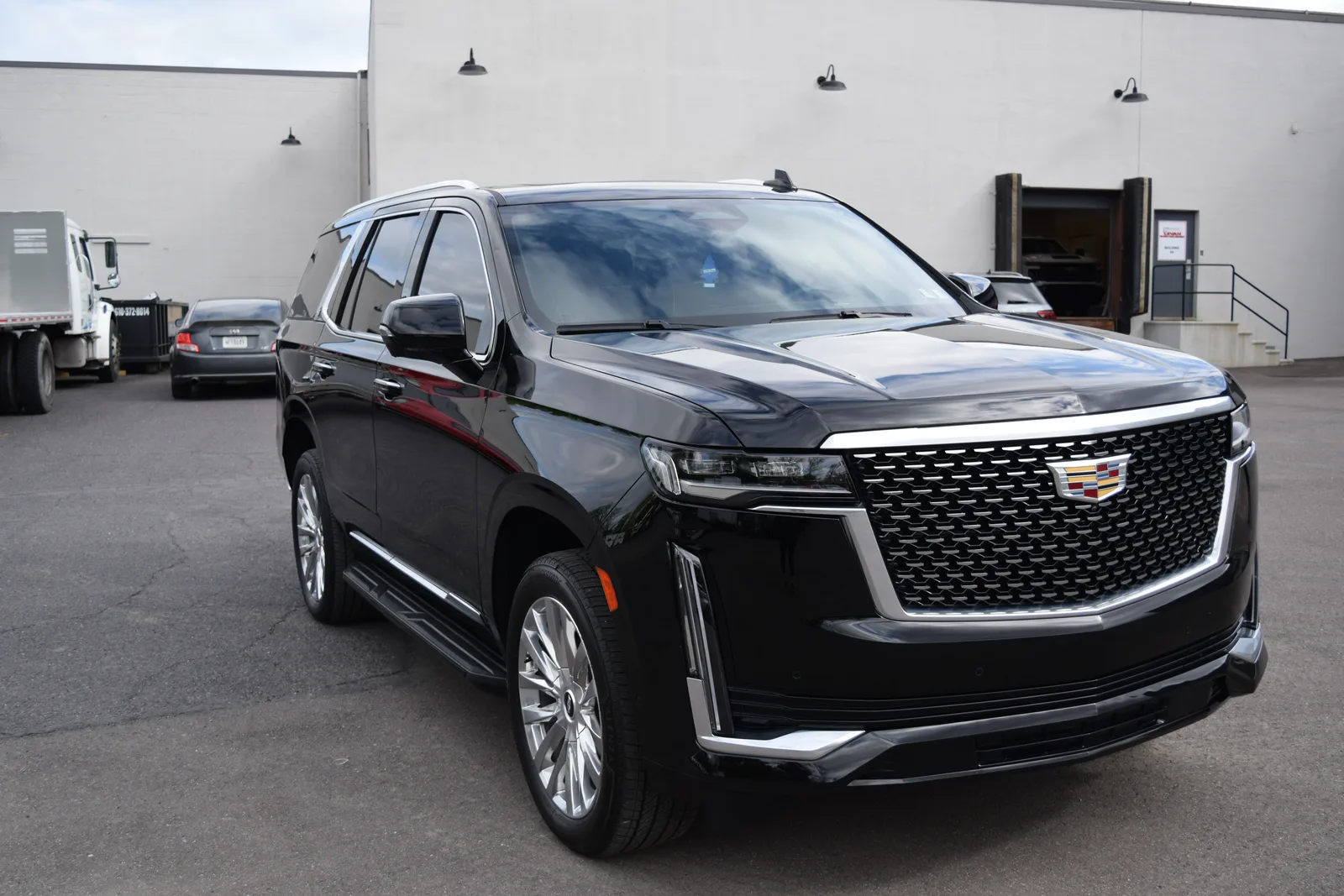 Black Cadillac Escalade outdoors at the Heritage shop, front three-quarter view