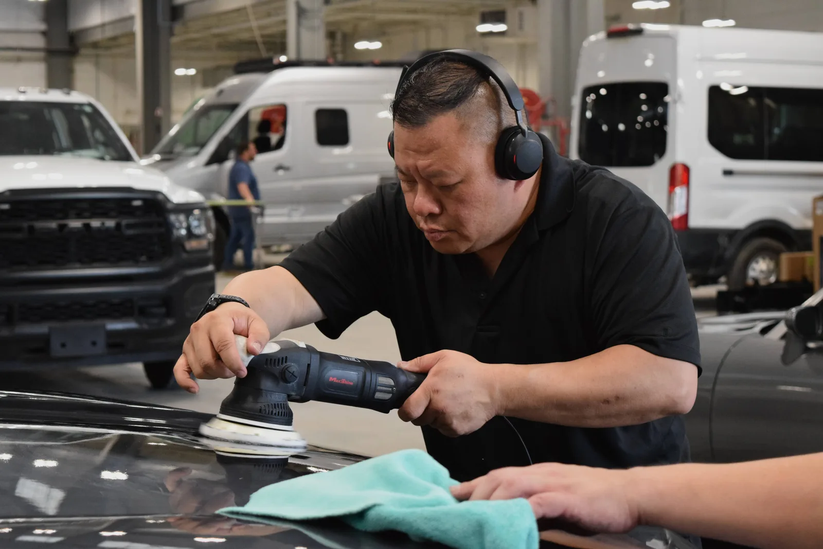 Heritage technician machine polishing a black hood with a dual-action orbital polisher after PeelClear cure