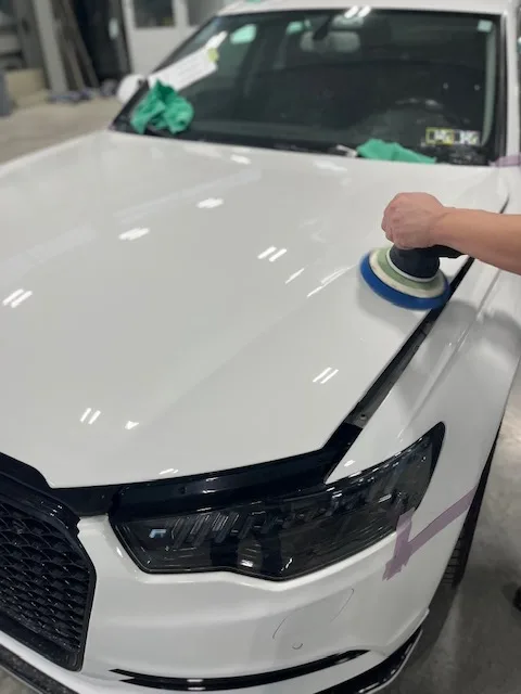 White 2015 Audi A6 hood being polished with a small DA polisher to refine the finish after PeelClear cure