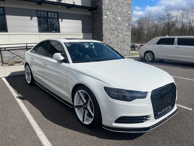 White Audi A6 sedan outdoors, front three-quarter, finished with full-front PeelClear